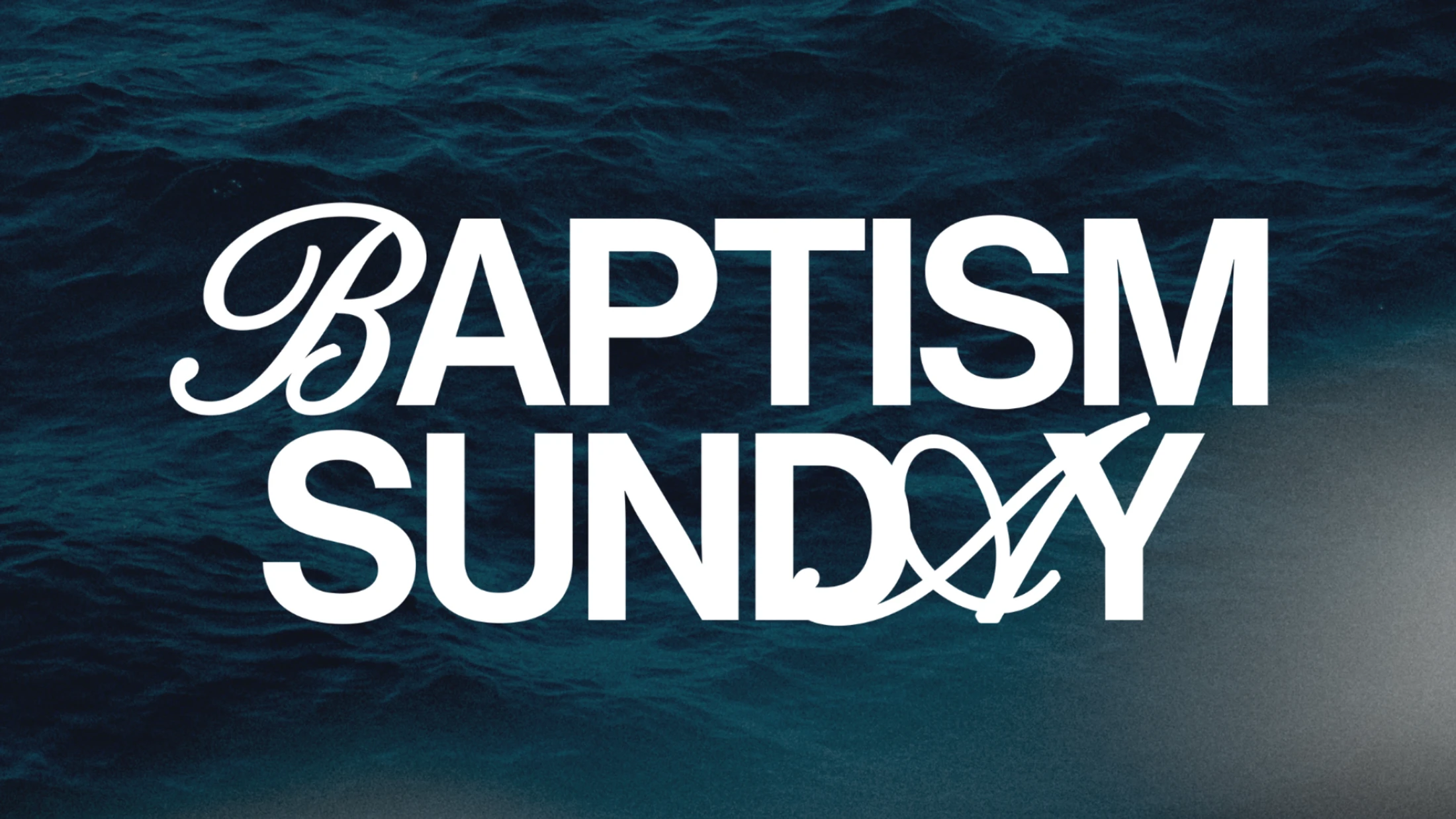 The words 'Baptism Sunday' in white stylized text over a background of dark blue rippling water. The 'ay' in Sunday incorporates a Christian fish symbol.