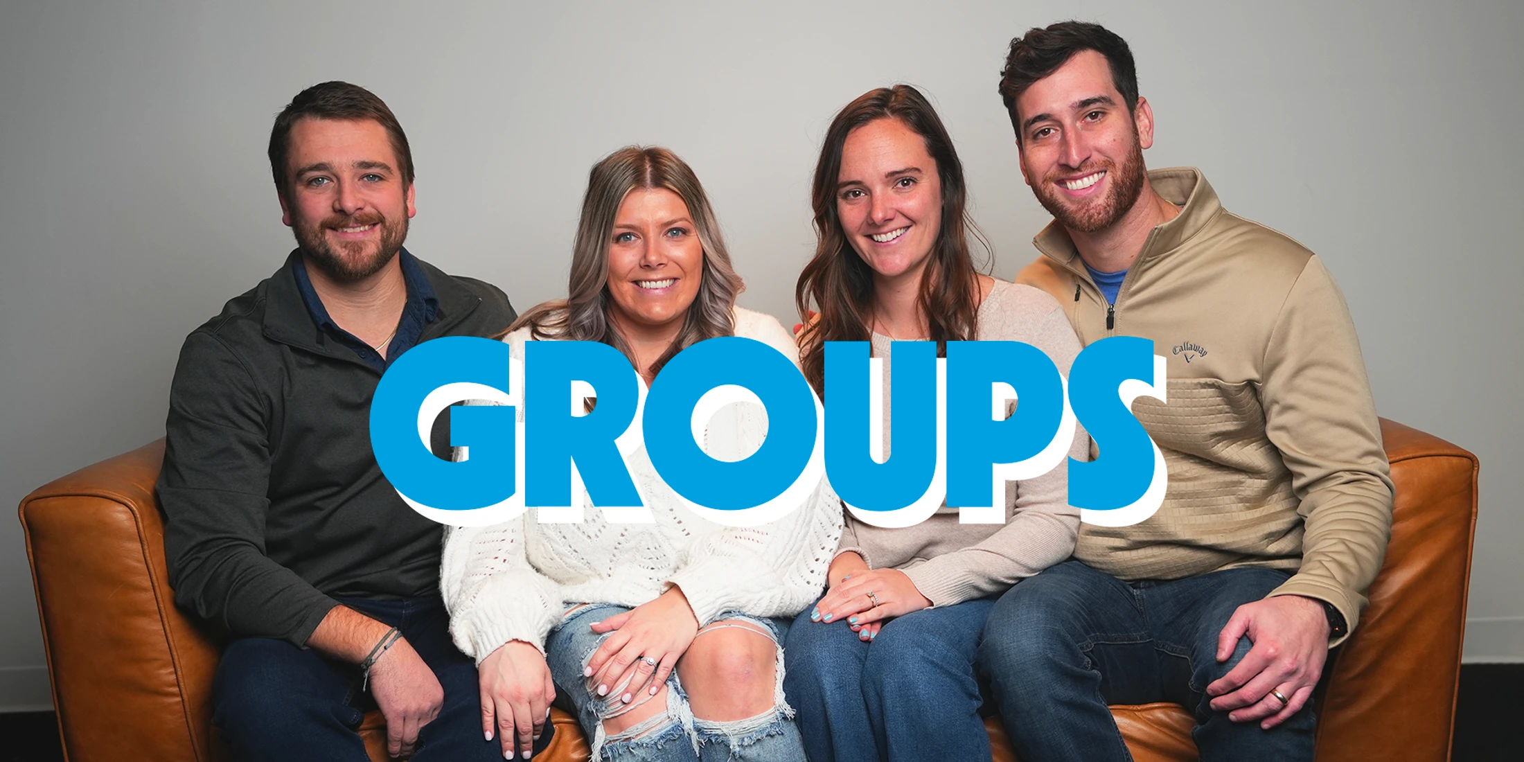 Two men and two women sit smiling on a brown leather couch with the word 'GROUPS' in large blue text layered over the center of the image.