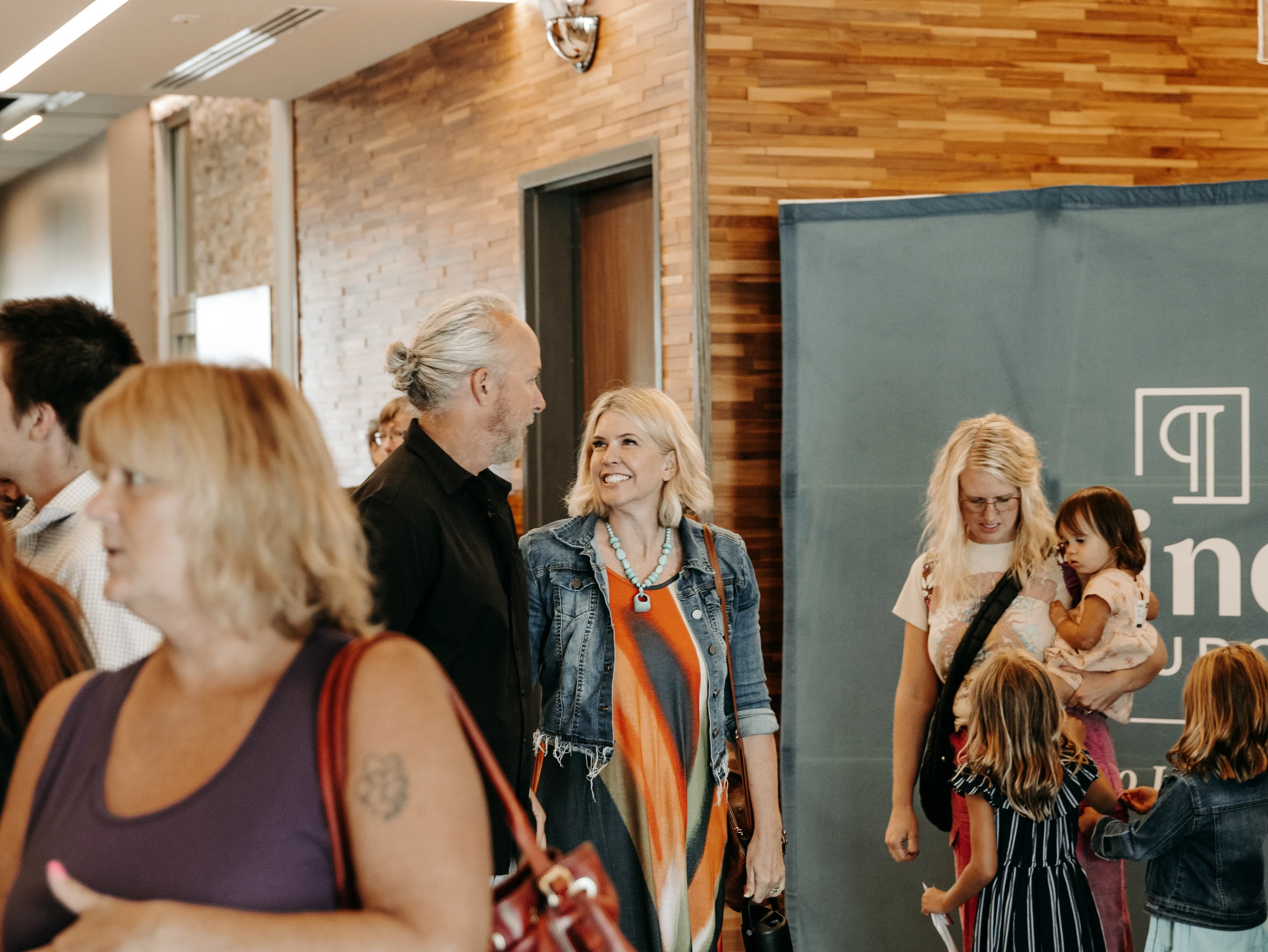 Families and friends talking together in the lobby at Alinea Church, a picture of real Christian community